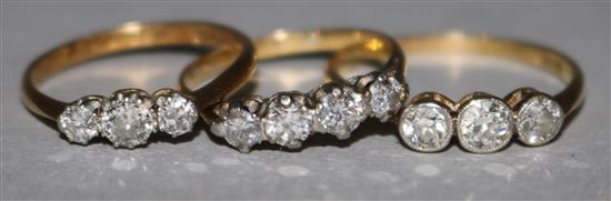 Two 1920s 18ct gold and three stone diamond rings and a gold and four stone diamond ring.